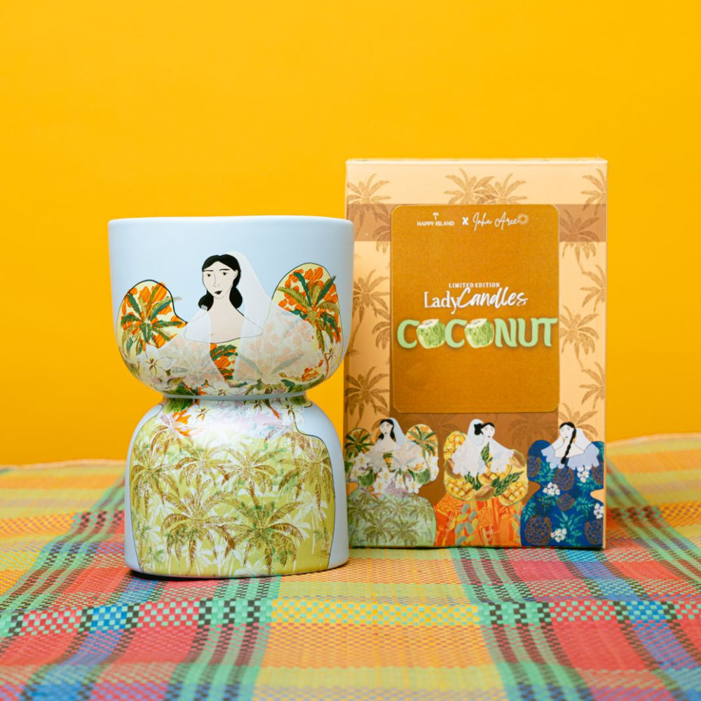 Decorative candle with a box labeled 'Coconut' on a colorful checkered tablecloth against a yellow background